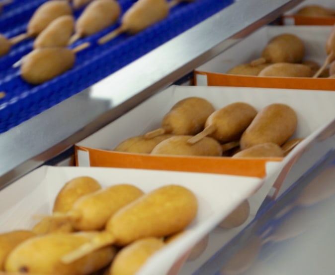 corn dogs being packaged on the line