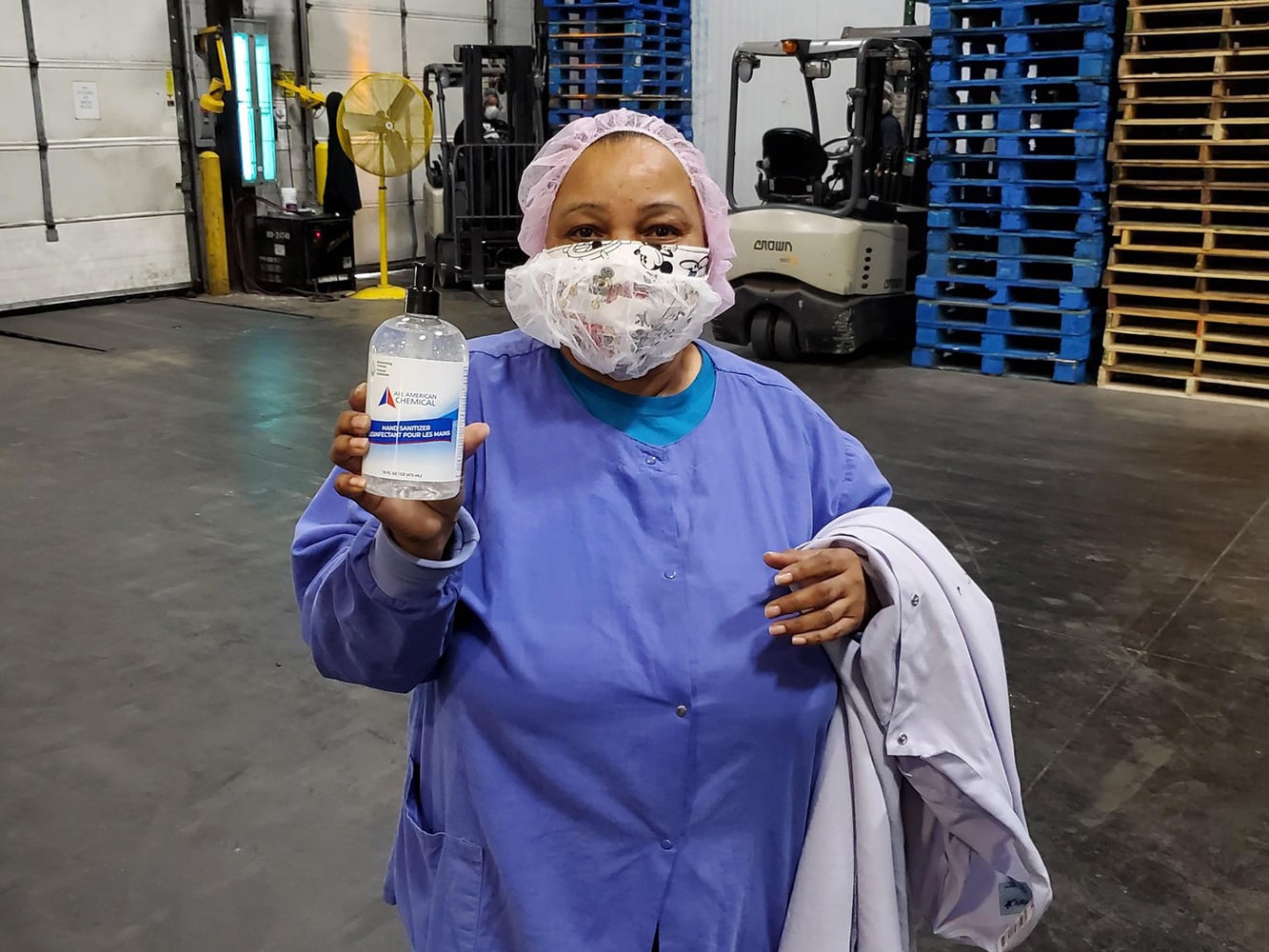 Martinsville employee holds bottle of hand sanitizer