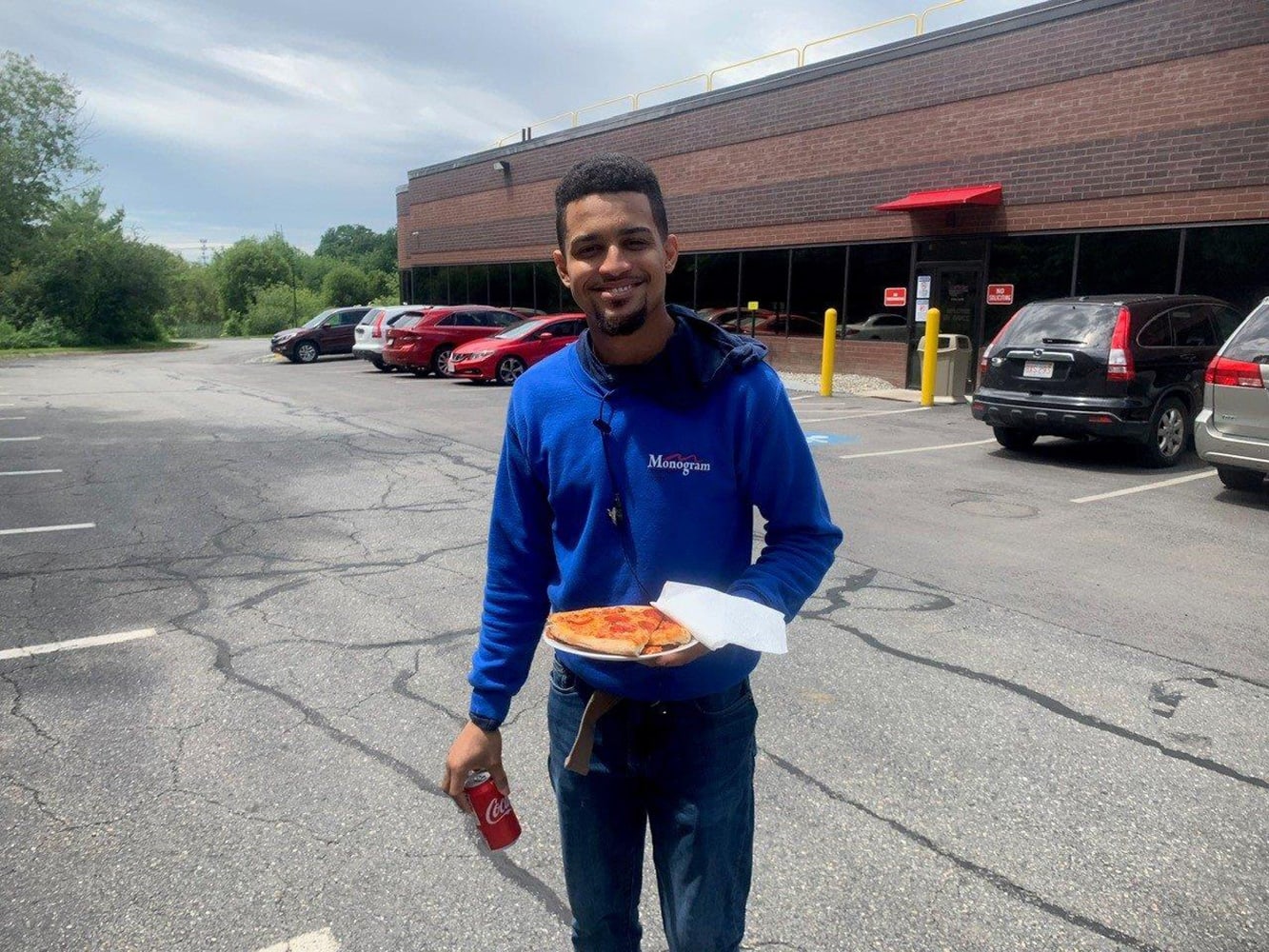 employee holds plate of pizza during pizza party